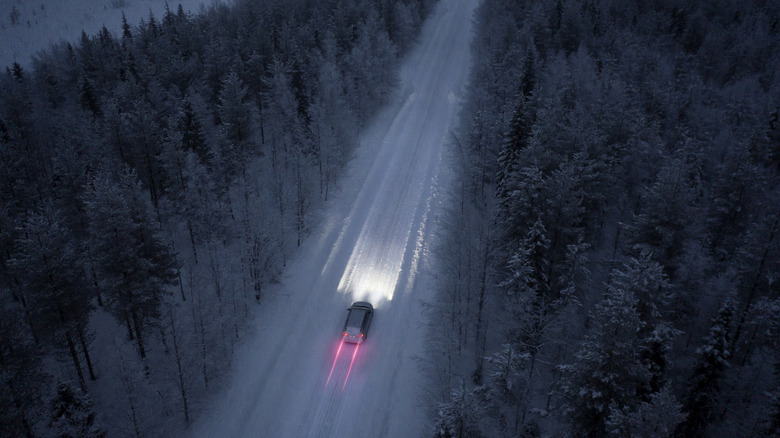 Aerial view of a snow road going through in the snow covered forest in Finland