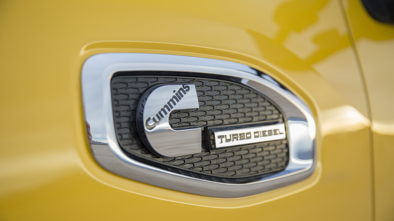 A fender Cummins badge on a yellow 2016 Nissan Titan XD