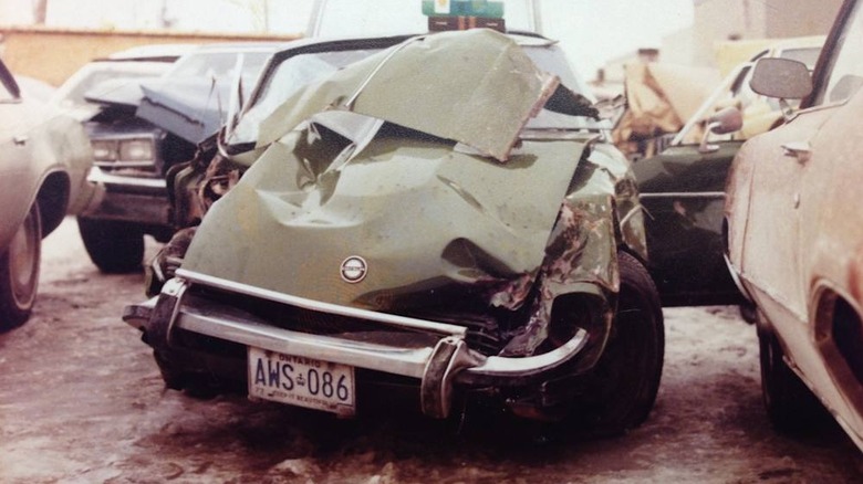 The wreckage of a crashed green Nissan 240Z