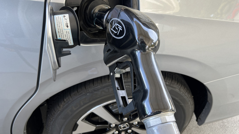 Gas pump nozzle inserted into the fuel tank of a Honda automobile at a Shell service station, Orinda, California, United States, August 16, 2026.