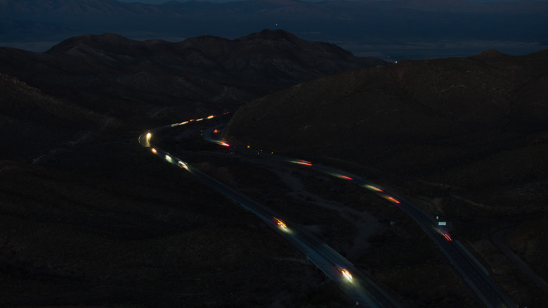 In an aerial view, vehicle lights along Interstate 15, through which the Brightline West high-speed rail will run, snake across the Mojave Desert on April 06, 2026 at Mountain Pass, California.