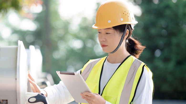 Female technician moving astatine EV charging station