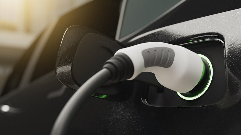 An electric car being charged with sunlight in the background.