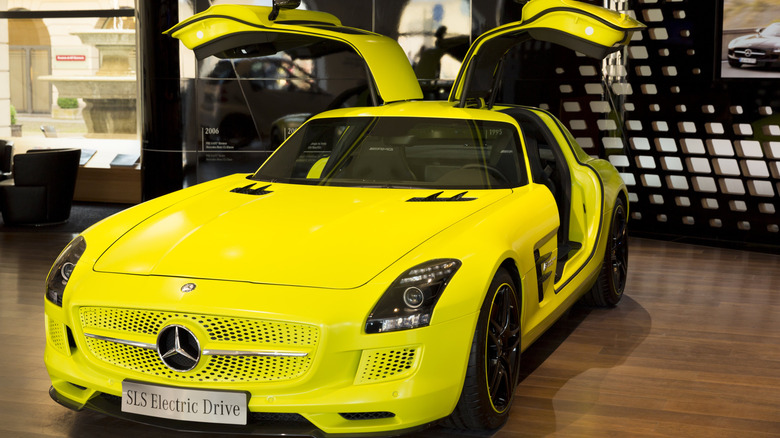 A Mercedes-Benz SLS AMG Electric Drive parked on display with its gullwing doors open and raised.