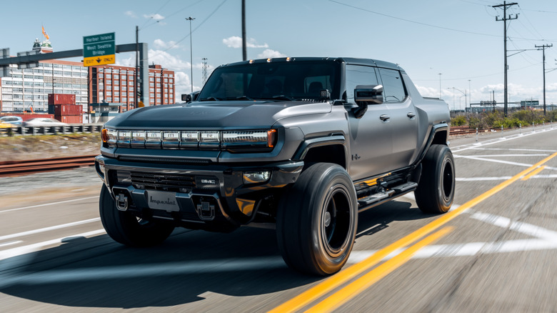 Seattle, WA, USA April 17, 2023 Hummer EV in black driving on the street with a cloud overhead