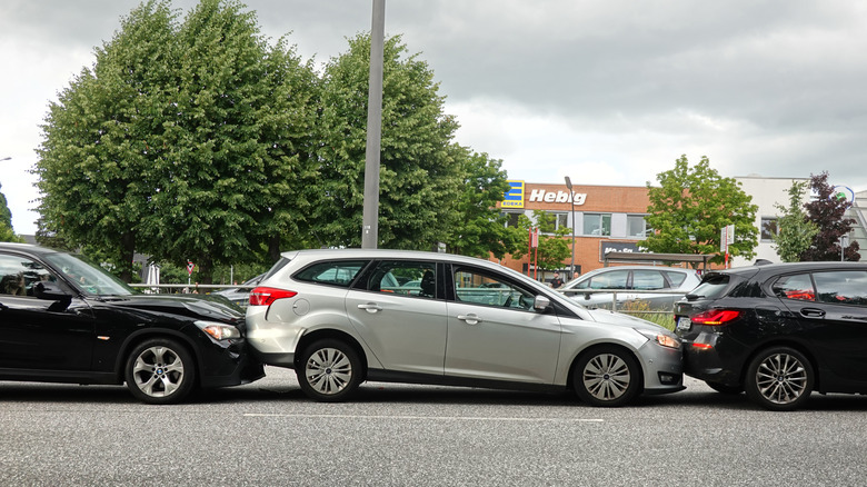 A silver Ford Focus estate being rear-ended in busy urban traffic
