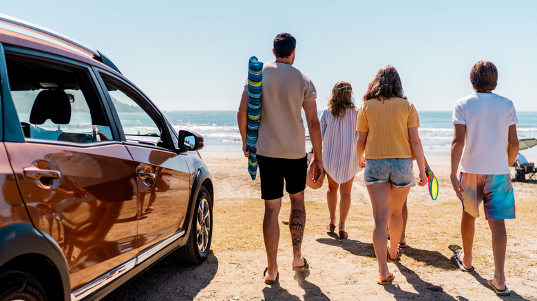 A family at the beach next to their car