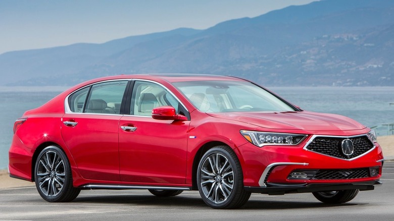 front three quarters shot of a red Acura RLX SH-AWD parked on asphalt in front of a view of the ocean and mountains