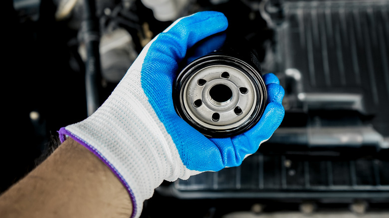 Mechanic holding an oil filter.