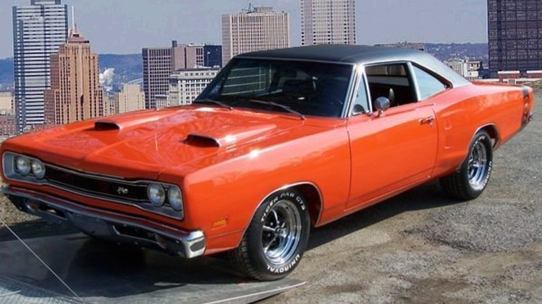 Orange 1969 Dodge Super Bee seen from left front parked overlooking a city skyline