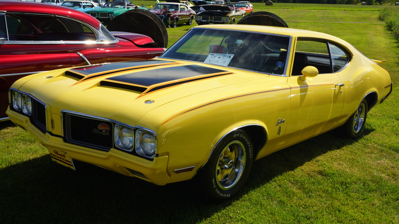 Yellow 1970 Oldsmobile Rallye 350 coupe seen from left front parked at outdoor car show