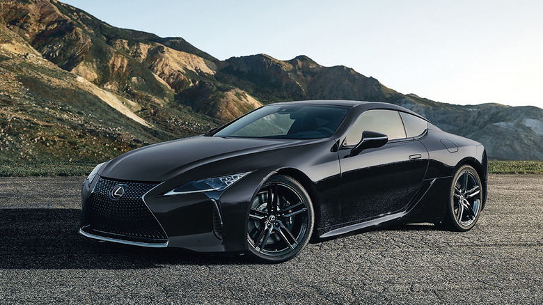 front three quarters shot of a black Lexus LC 500 parked on asphalt in front of mountains