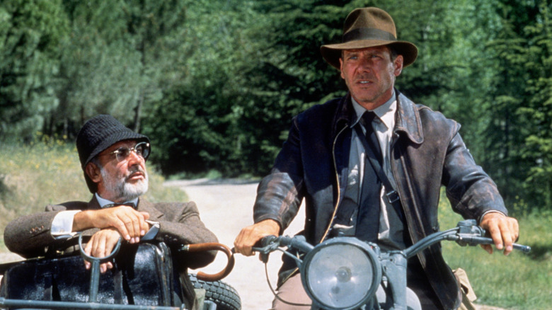 American actor Harrison Ford as the eponymous archaeologist and Scottish actor Sean Connery as his father Henry Jones during the motorcycle chase scene from the film 'Indiana Jones and the Last Crusade', 1989