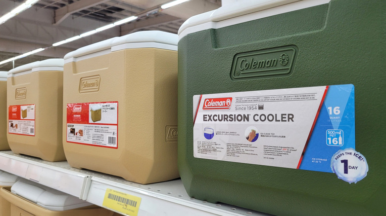 Coleman brand portable cooler box display on store shelf in shopping mall.