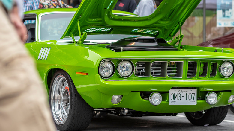 A green Plymouth Hemi 'Cuda on display with its hood popped.