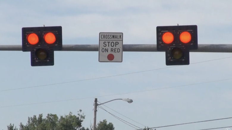 A Pedestrian Hybrid Beacon with a sign saying "Crosswalk: Stop on red"