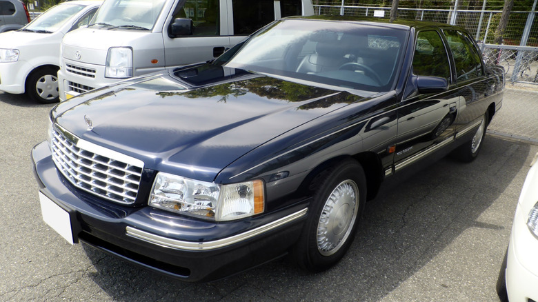 A dark blue Cadillac DeVille in a parking lot