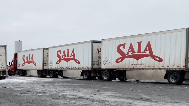 A red triple pup semi tractor trailer in a stockyard