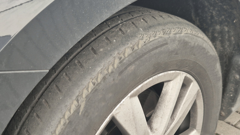 A close-up shot of a tire worn on the outter edge.