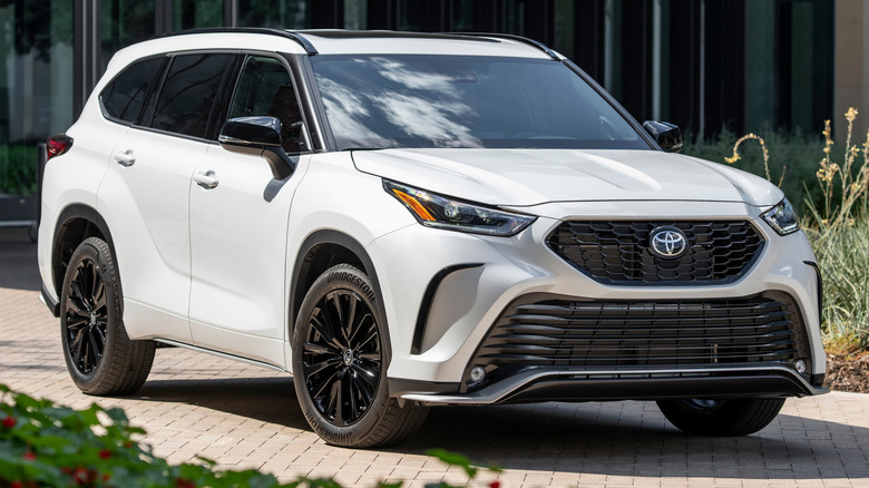 Wind Chill Pearl 2025 Toyota Highlander XSE parked on a paved surface in front of a building