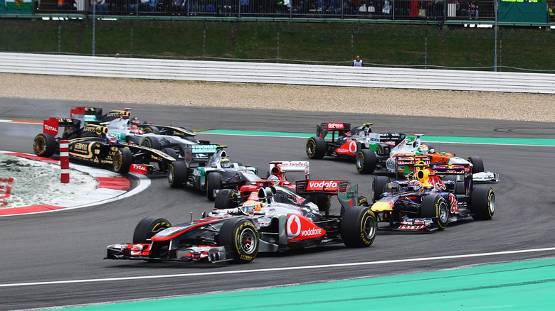 Lewis Hamilton (C) of Great Britain and McLaren takes the lead at the first corner during the start of the German Formula One Grand Prix at the Nurburgring on July 24, 2011 in Nuerburg, Germany.