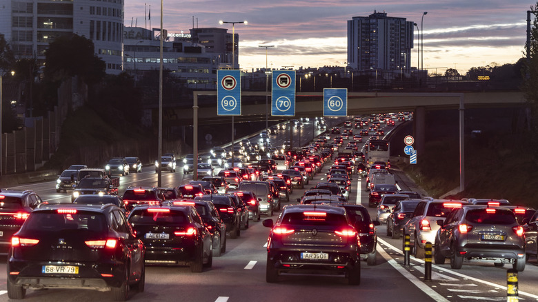 Vehicles drive bumper to bumper through A5 highway at dusk rush hour