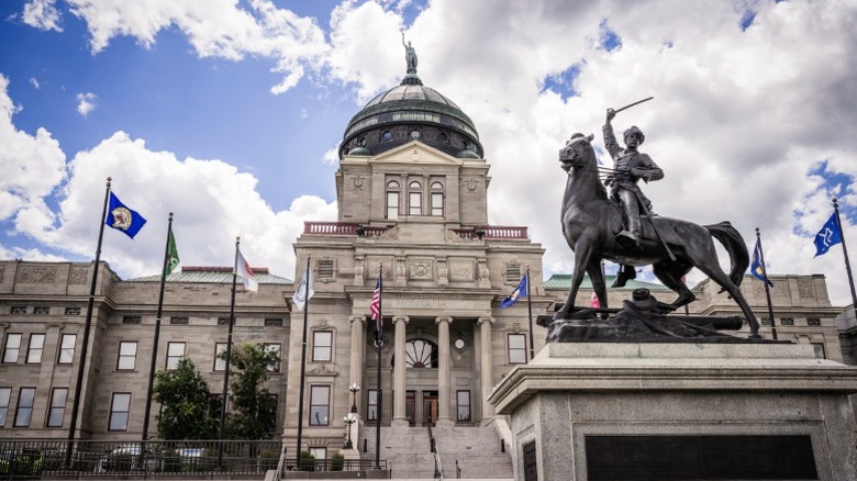 The Montana state capitol building with a statue in front of it