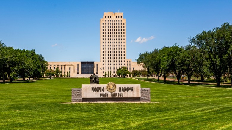 A far view of the North Dakota capital building with a sign labeling it