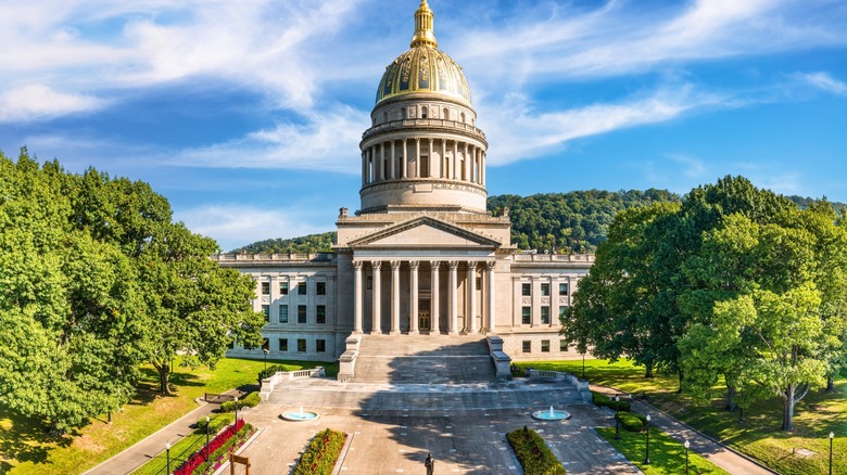 A view of the West Virginia state house with trees beside it