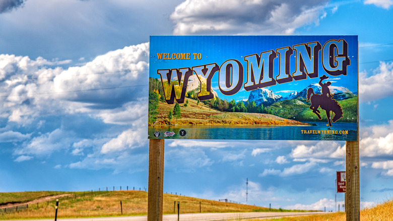 A Wyoming welcome sign with a blue sky behind it