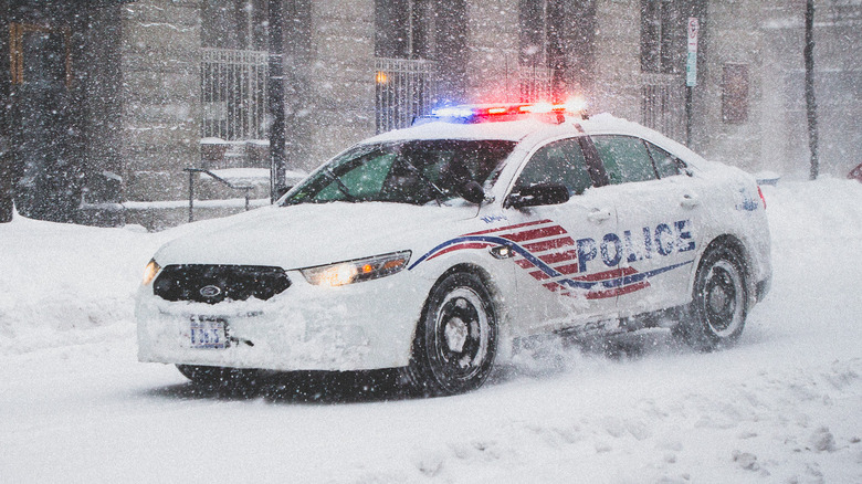 A District of Columbia police car driving through heavy snow.