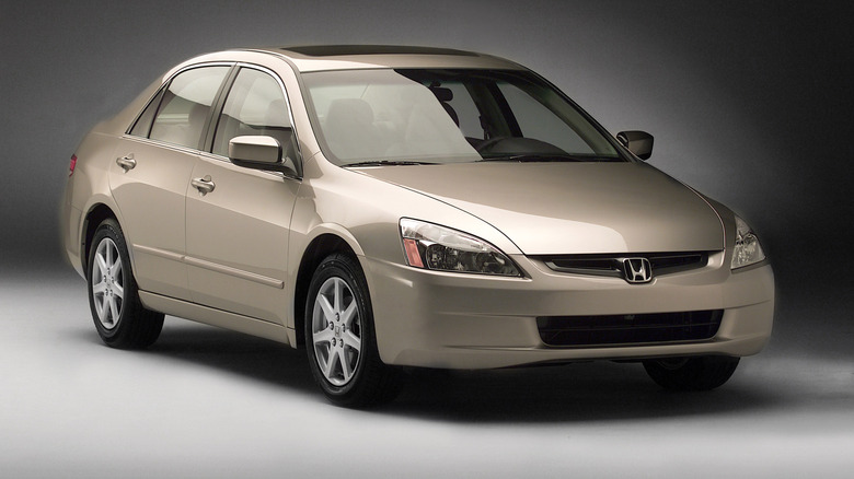 A gold 2004 Honda Accord in a studio setting.