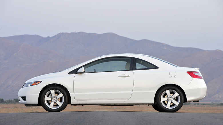 A white 2007 Honda Civic is parked against mountains.