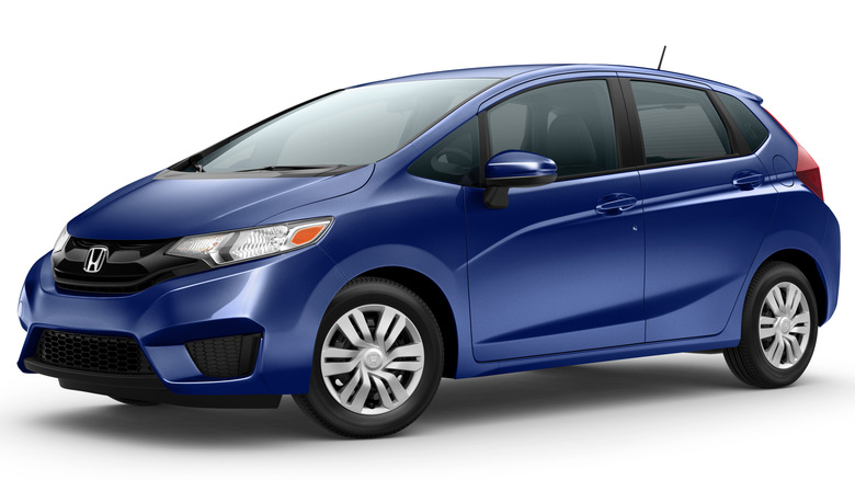 A blue 2015 Honda Fit sits under studio lighting.