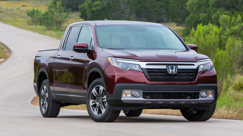 A red 2019 Honda Ridgeline sits parked on a road.