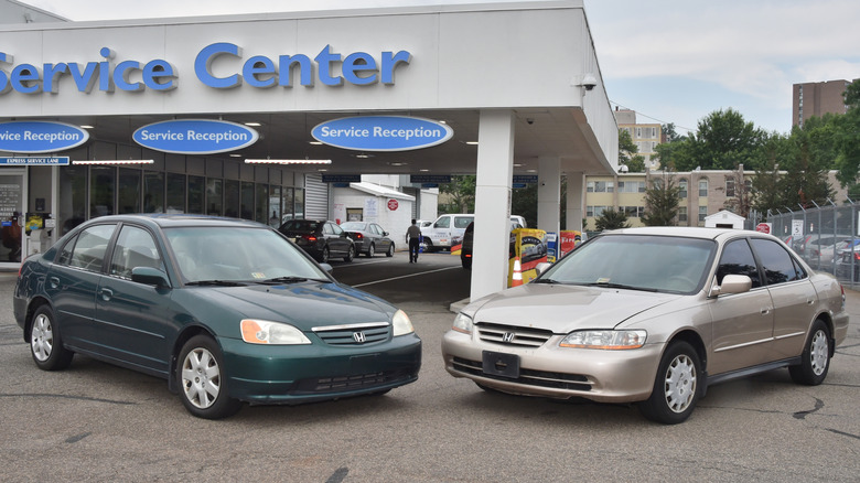A Honda Civic and a Honda Accord sit in front of a service center.