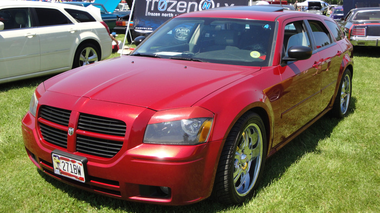 A red 2005 Dodge Magnum in a grass lot at a car meet