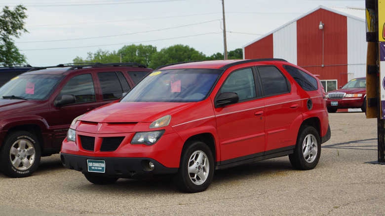 A red 2003 Pontiac Aztec in a parking lot