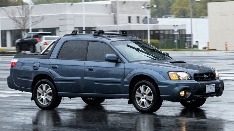 A dark blue Subaru Baja on a rainy day