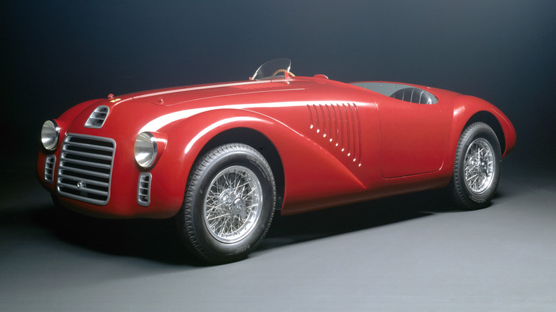 Red Ferrari 125 S race car seen in left front three-quarter view in studio