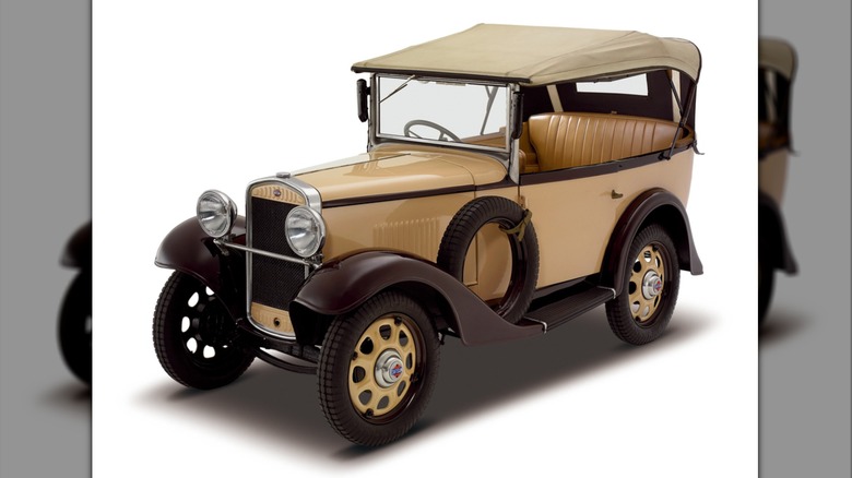 Tan 1933 Nissan Datsun Type 12 Phaeton convertible seen in left front three-quarter view in studio