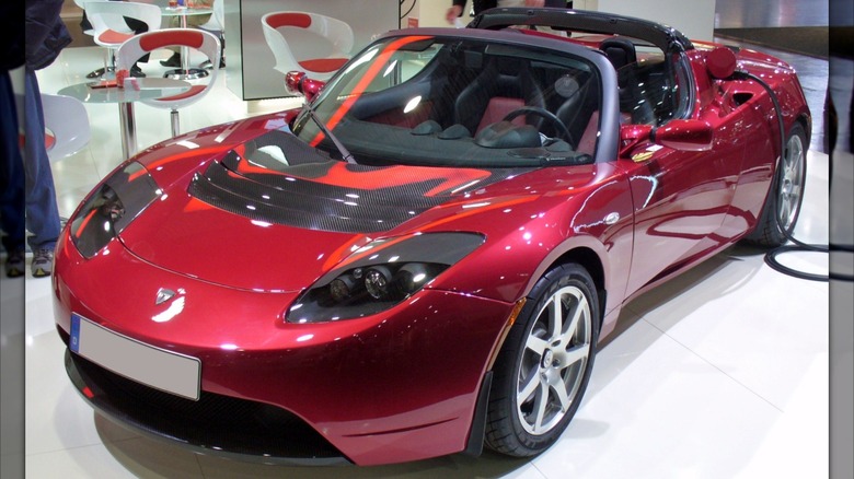 Red Tesla Roadster seen in left front three-quarter view on display indoors