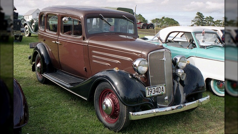 This is a 1938 Chevrolet Master Deluxe Sedan on a sales floor.