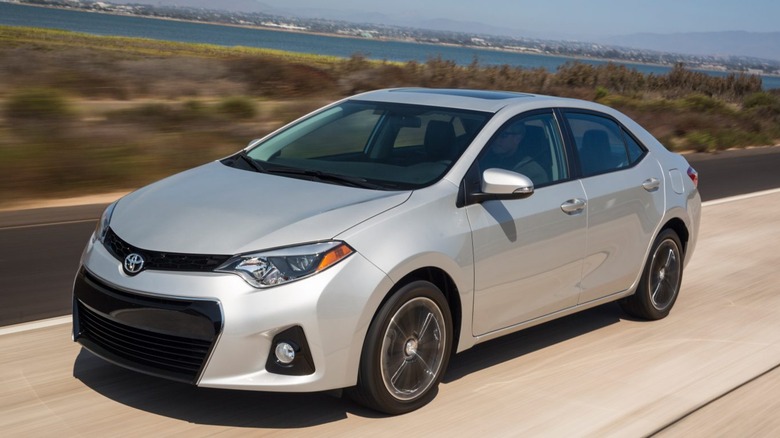 A 2010s Toyota Corolla driving on the highway.