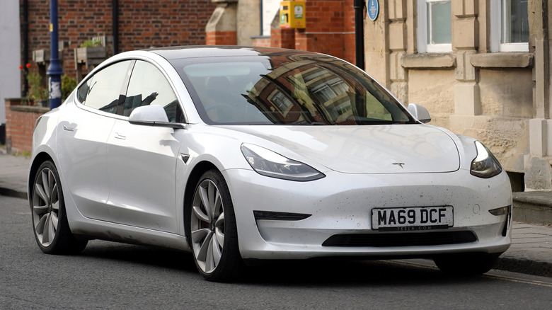 This is a 2023 Tesla Model Y parked on a quiet European street.