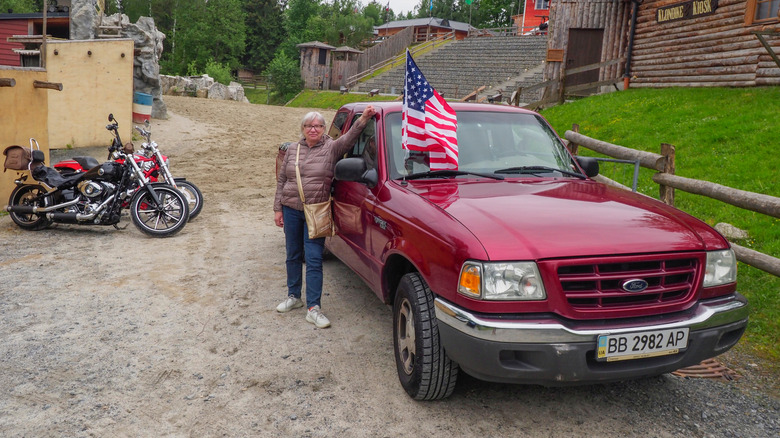 A woman posing next to a red Ford Ranger