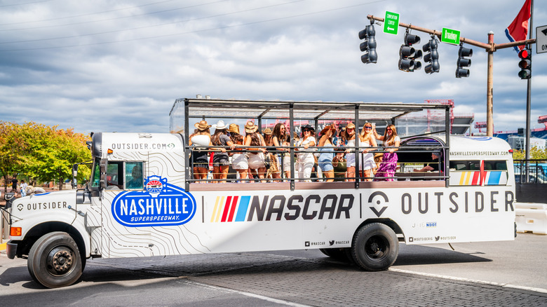 NASCAR-themed open platform bus full of women celebrating and having fun in downtown Nashville
