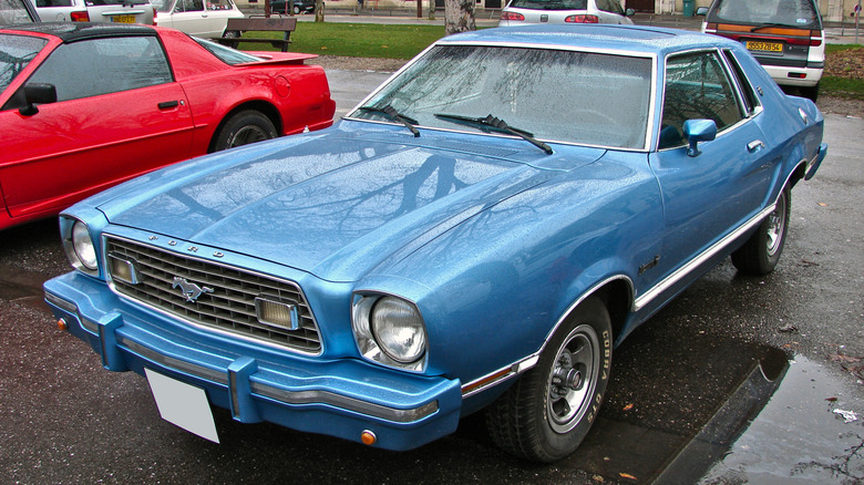 A blue Ford Mustang II at a car meet