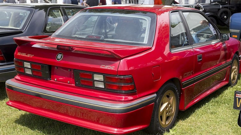 Rear quarter view of a red 1989 Dodge Shelby CSX-VNT with gold plastic wheels