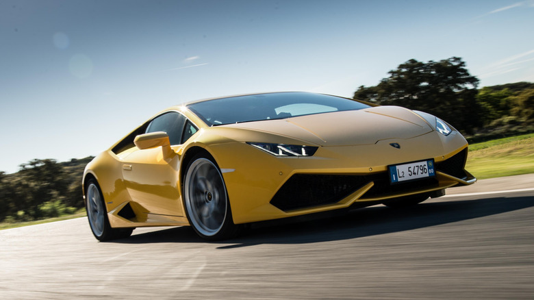 A yellow 2014 Lamborghini Huracan Coupe sports car driving on a road